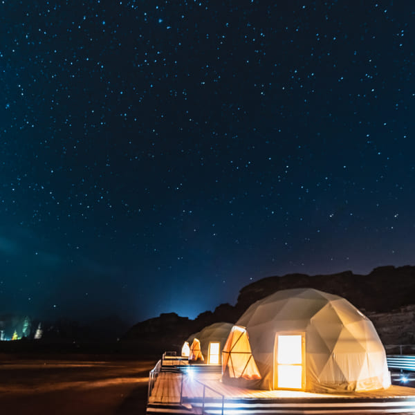Les étoiles brillent au-dessus des tentes la nuit.
