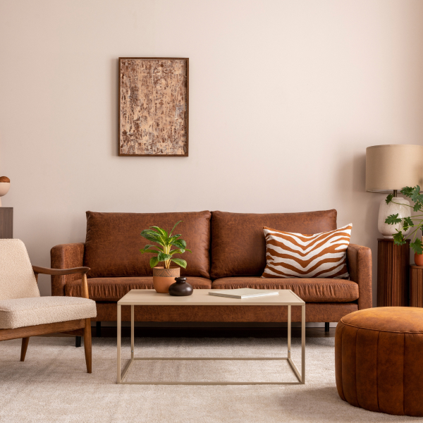 Un salon avec un canapé et un fauteuil en cuir marron.